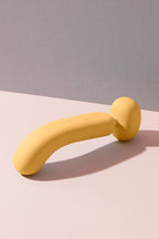 A dual-ended yellow wand massager with a smooth, curved design, made from soft silicone material.
